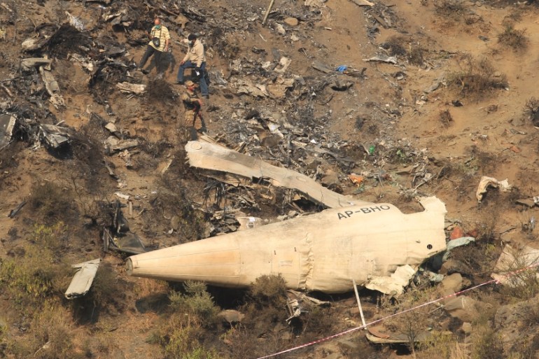 Rescue workers survey the site of a plane crash in the vilage of Saddha Batolni near Abbotabad
