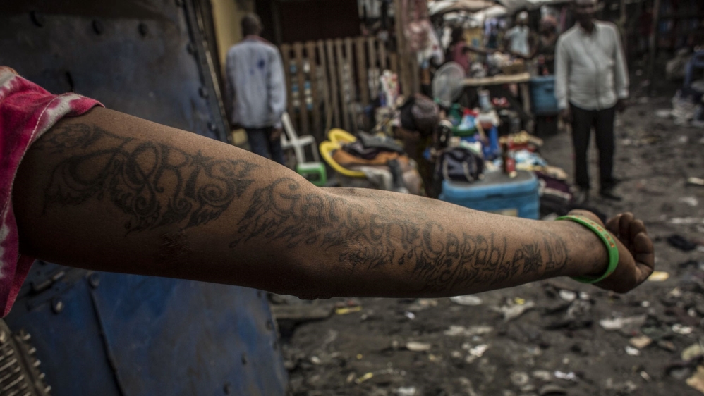 A man shows his forearm taboos in the Lubugi district of Kinshasa [Francesca Volpi/Al Jazeera]