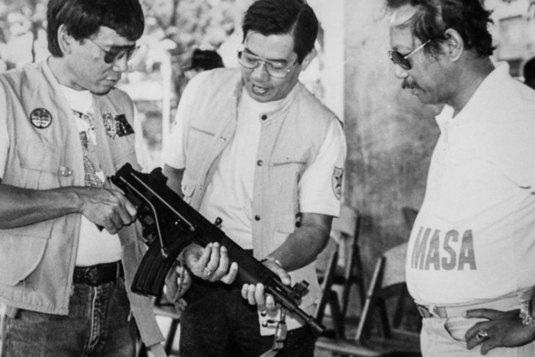 Mayor Rodrigo Duterte inspects an assault rifle in Davao city in the southern Philippines