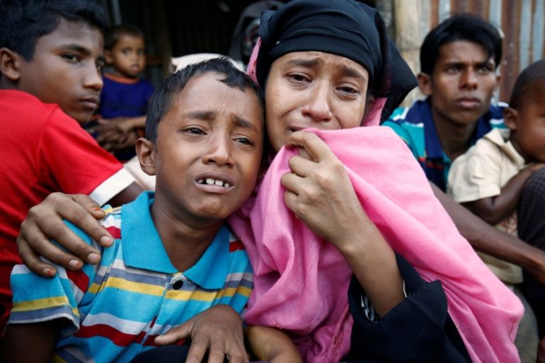A Rohingya Muslim woman and her son cry after being caught by Border Guard Bangladesh while illegally crossing at a border check point in Cox’s Bazar