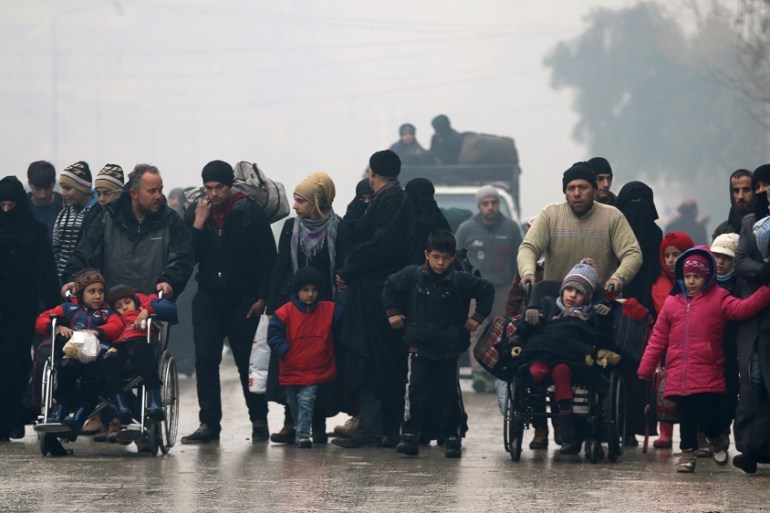 People walk as they flee deeper into the remaining rebel-held areas of Aleppo