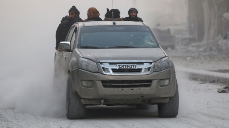 Rebel fighters ride on a pick-up truck in a rebel-held area of Aleppo