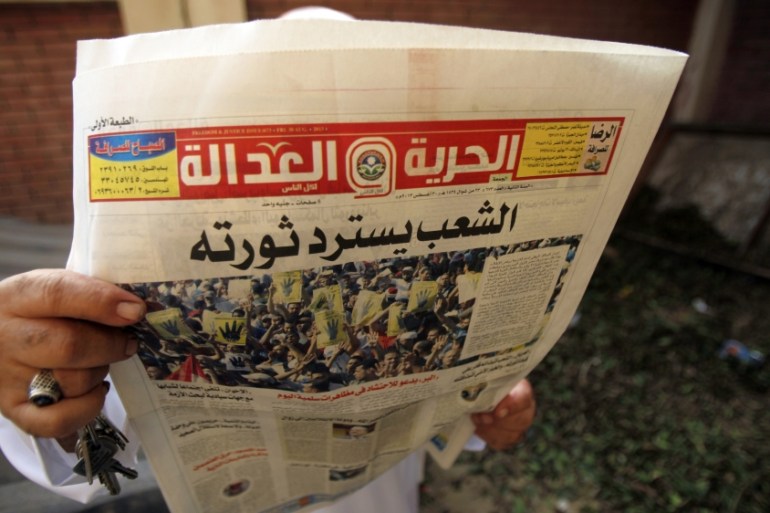 Egyptian man reading newspaper