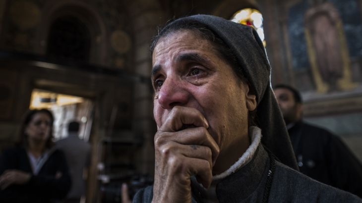 A nun reacts as Egyptian security forces (unseen) inspect the scene of a bomb explosion at the Saint Peter and Saint Paul Coptic Orthodox Church