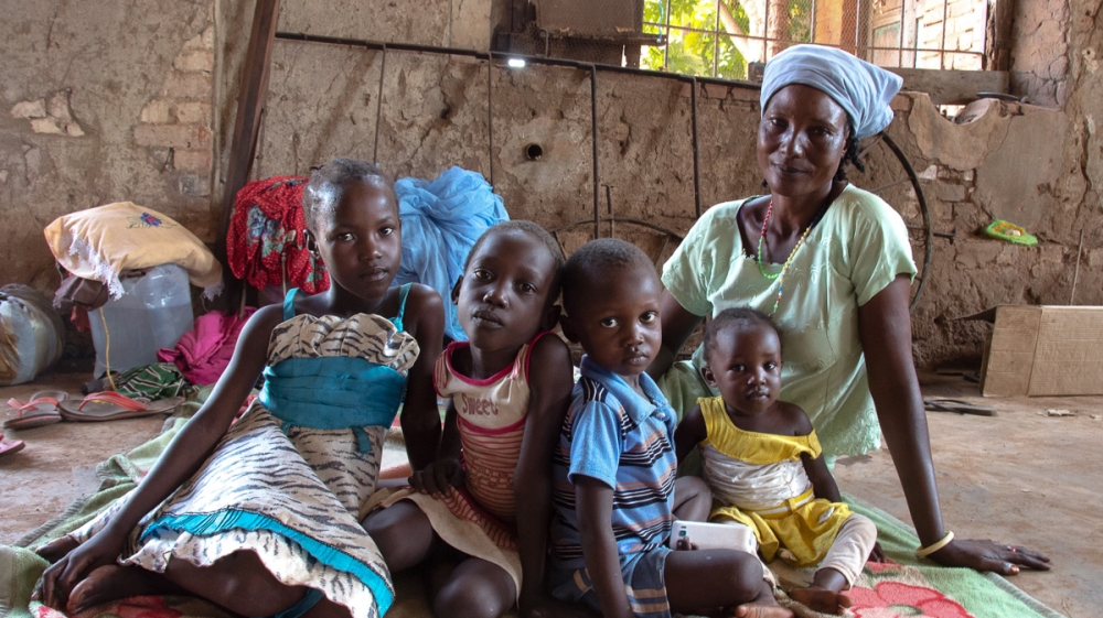 Elizabeth and her four of her five children at St Mary’s Cathedral compound, Wau. They travelled 11 hours on foot through the night to escape the violence [Richard Nield/Al Jazeera]
