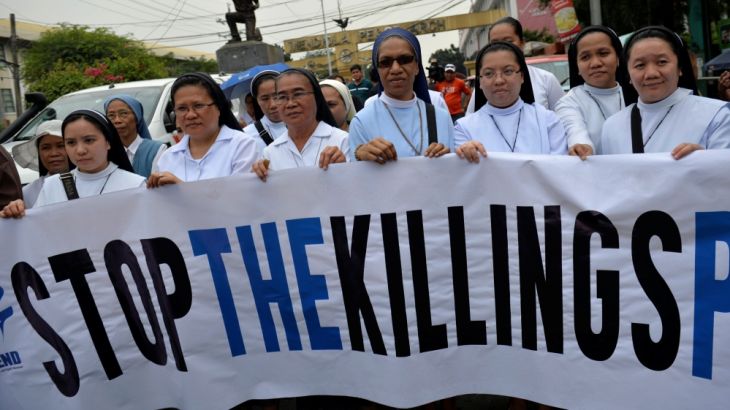 Catholic nuns hold up a banner as they protest against what organisers say are drug-related extrajudicial killings, during the International Human Rights Day in Manila