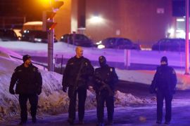 Police officers patrol the perimeter near a mosque after a shooting in Quebec City