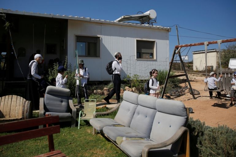 Visitors walk in a yard near a home in the Jewish settler outpost of Amona in the West Bank, during an event organised to show support for Amona