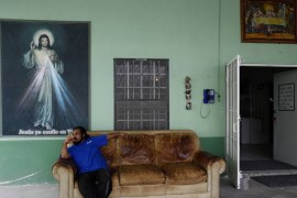 A man sits on a couch at Casa del Migrante in Reynosa, Mexico