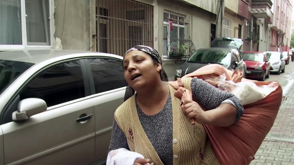 Yasemin walks the streets with her bundle of bed linen and curtains [Al Jazeera]