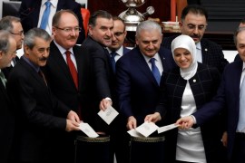 Turkish Prime Minister Binali Yildirim poses with MPs as he votes during a debate on the proposed constitutional changes at the Turkish Parliament in Ankara