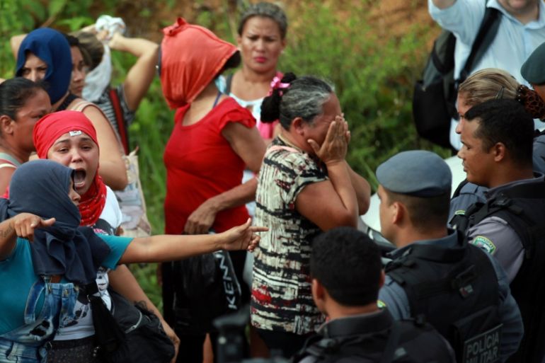 Relatives of prisoners react near riot police at a checkpoint close to the prison where around 60 people were killed in a prison riot in the Amazon jungle city of Manaus