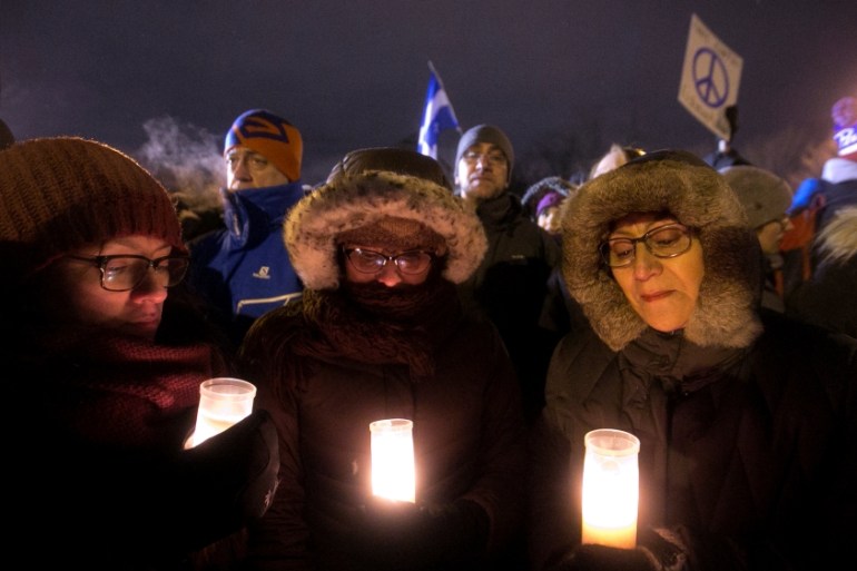 People hold candles as they attend a vigil in honour of the victims of a shooting in a Quebec mosque in Quebec City, Quebec