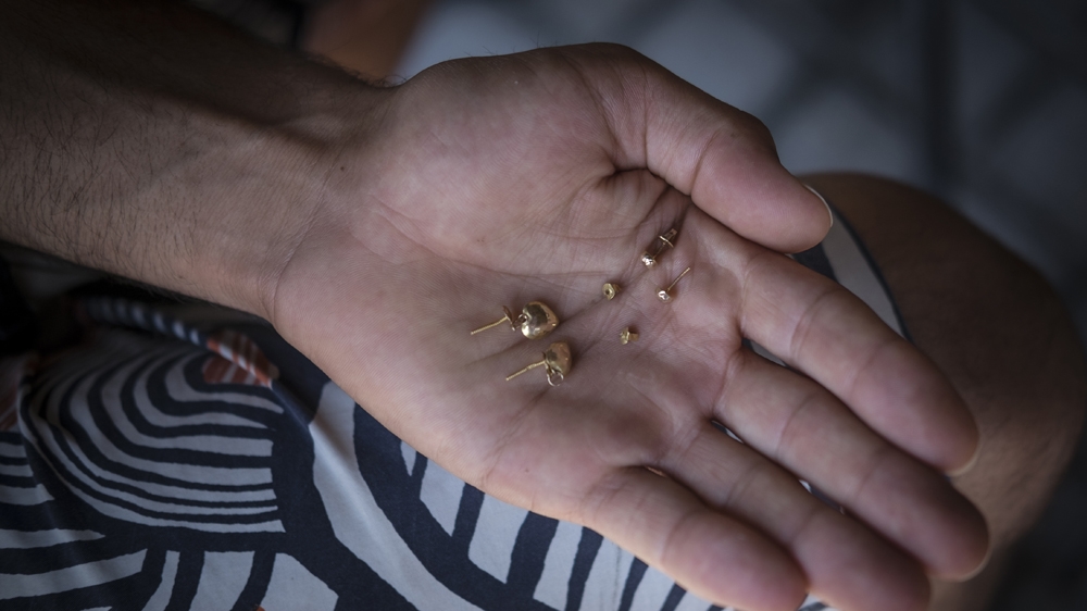 Two pairs of gold earrings, one belonging to Ghalia Abdi and the other to her daughter, were removed from their bodies and given to Ghalia's sister, Shadia Abdi [Fahrinisa Oswald/Al Jazeera]