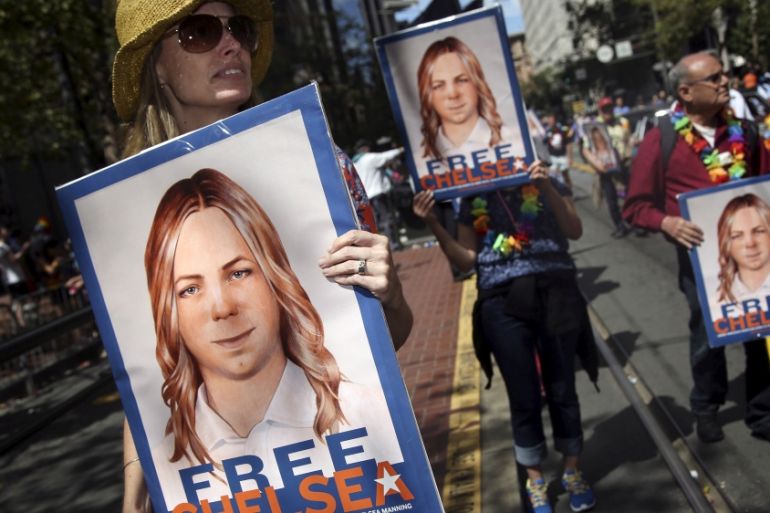 FILE PHOTO -- People hold signs calling for the release of imprisoned wikileaks whistleblower Chelsea Manning while marching in a gay pride parade in San Francisco, California