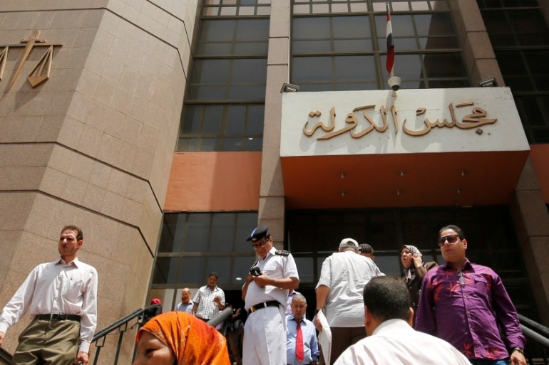 A policman and people walk at the entrance of the State Council''s building, Egypt''s highest administrative court in Cairo, Egypt