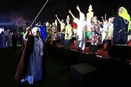 Bashir waves to traditional performers in Khartoum