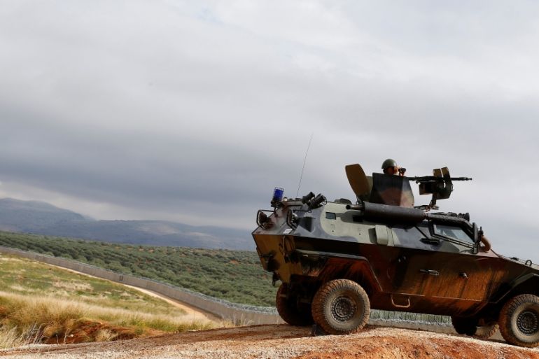 A Turkish soldier on armoured military vehicle patrols the border between Turkey and Syria, near the southeastern village of Besarslan, in Hatay province