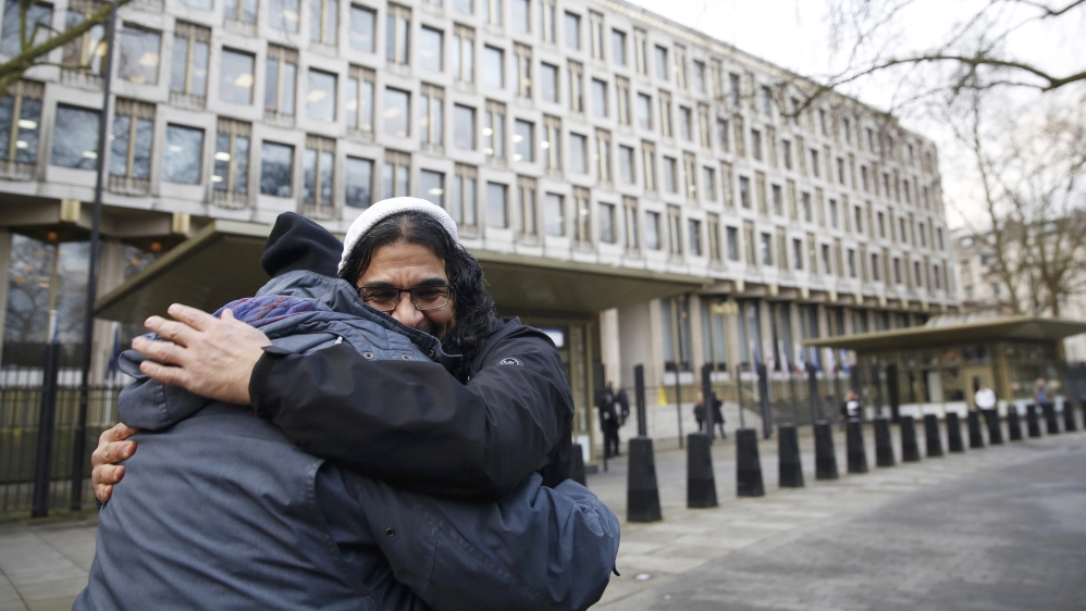 Aamer hugs a supporter at a protest outside the US embassy in London [File: Luke MacGregor/Reuters]