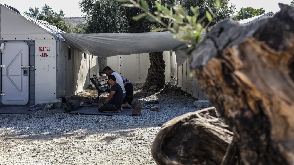 Three of the six survivors pray in the shade at Kara Tepe camp on Lesbos island. Immediately after being rescued, the six survivors were taken to Moria refugee camp to register and afterwards to the hospital for medical examinations. They were then taken to Kara Tepe refugee camp where more than 1,000 vulnerable refugees live. July 2016. [Fahrinisa Oswald/Al Jazeera]