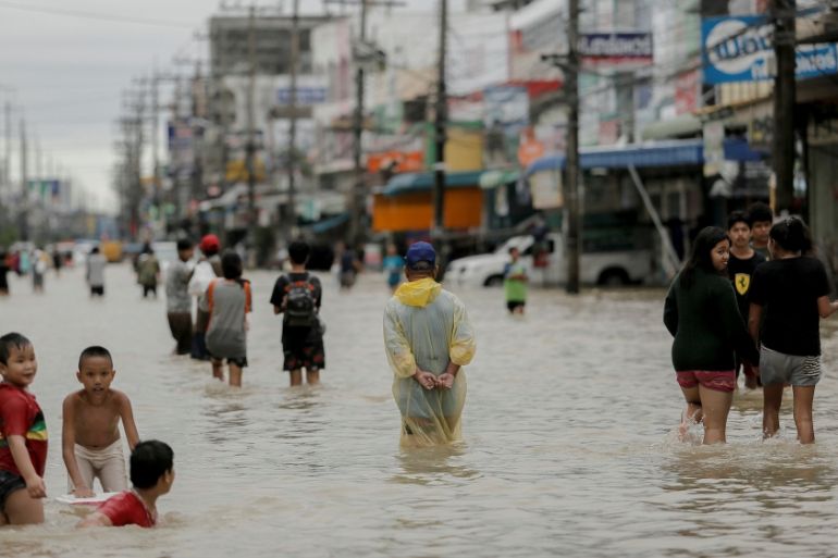 People walk in a flooded street at Muang district in Nakhon Si Thammarat Province