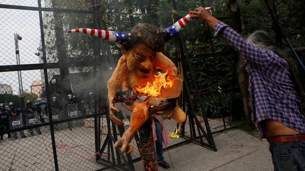 Demonstrators burned an effigy of US President Donald Trump during a protest against a fuel price rise outside the US embassy in Mexico City [Henry Romero/Reuters]