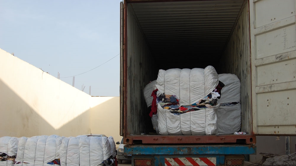 Shipments of donated clothing arrive from the UK several times a month [Ndela Faye/Al Jazeera]