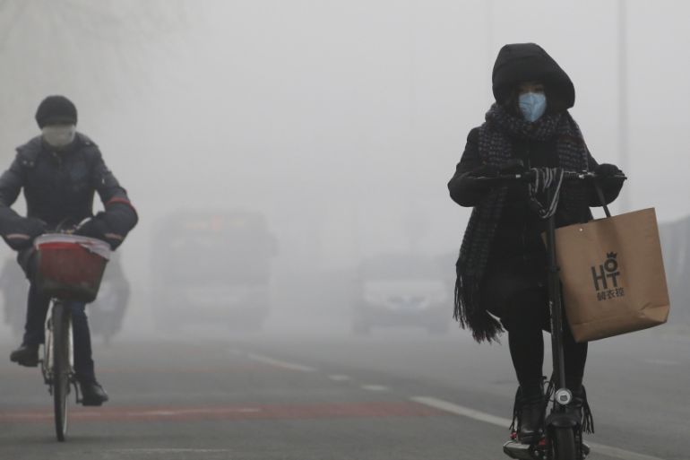 People ride amid the smog in Beijing