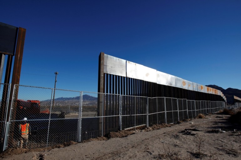 A worker stands next to a newly built section of the U.S.-Mexico border fence at Sunland Park, U.S. opposite the Mexican border city of Ciudad Juarez