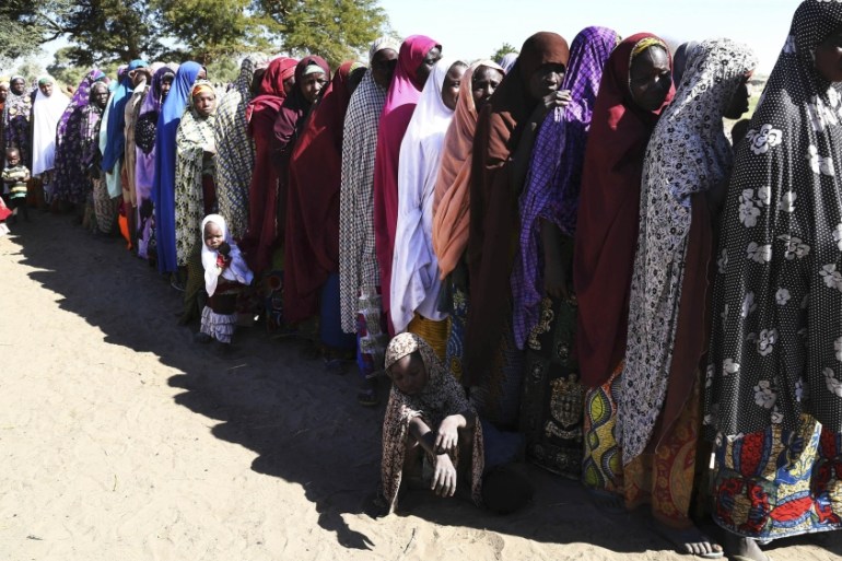 Women who have fled violence in Nigeria queue for food at a refugee welcoming center in Ngouboua