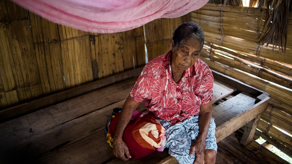 A blind Miskito women sits on her bed in her hastily built home in the Miskito refugee community of Pranza, Honduras. [Alex McDougall/Al Jazeera]