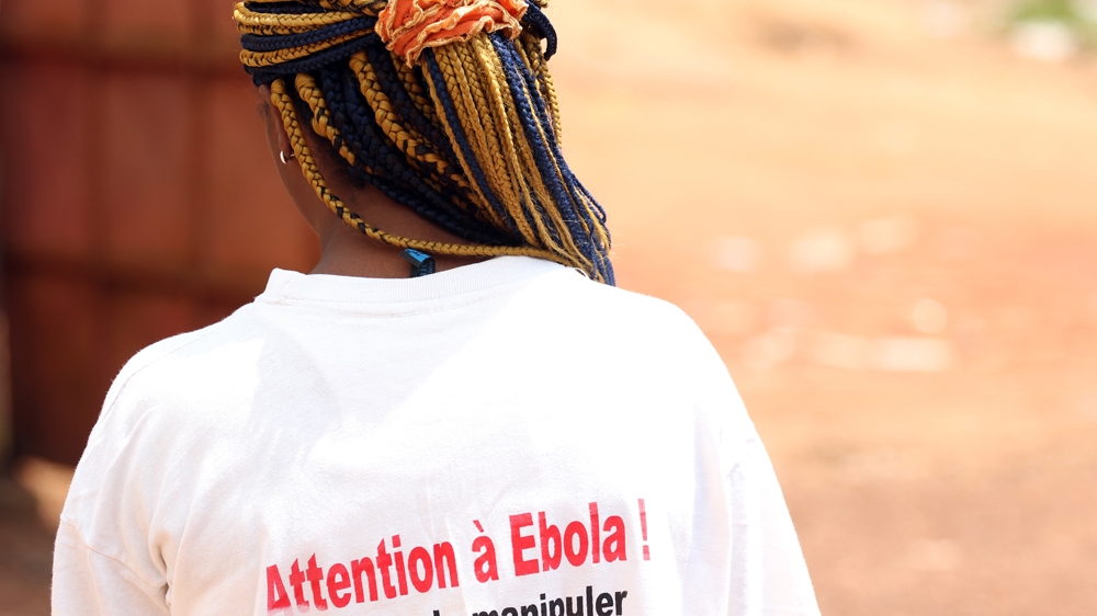 A young woman in the southern town of Kyo Essi on Cameroon's border with Equatorial Guinea displays an Ebola prevention message on her t-shirt [Eugene Nforngwa/Al Jazeera]