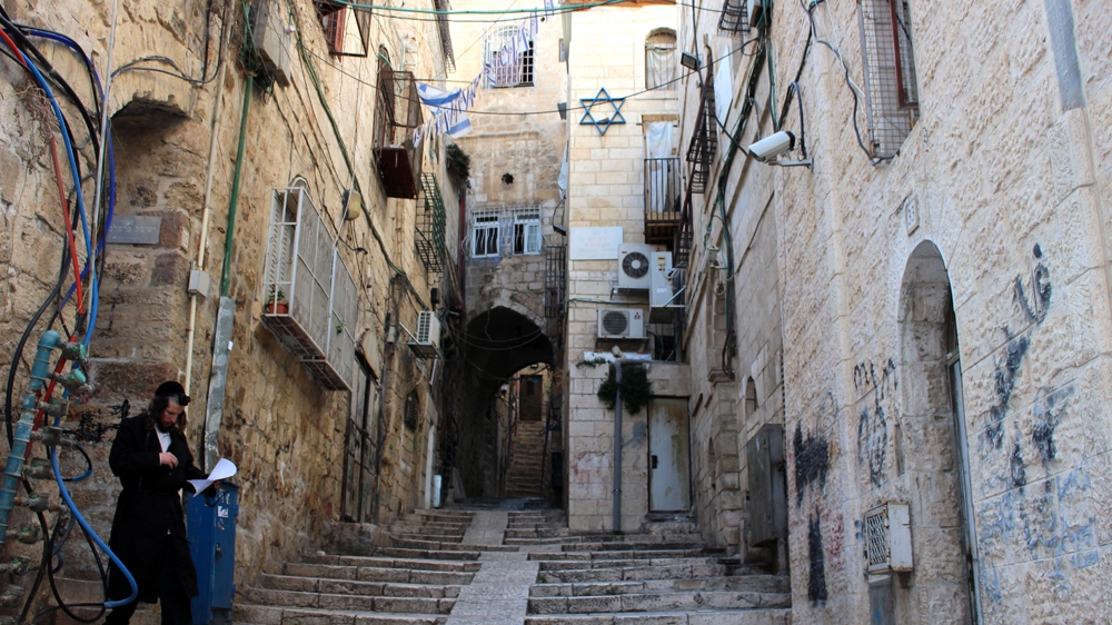 The street outside the Sub Laban family's apartment in the al-Khaldiya neighbourhood of the Old City is decorated with Israeli flags and symbols [Jaclynn Ashly/Al Jazeera]
