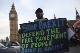 An anti-Brexit protester holds a sign outside the Houses of Parliament in London