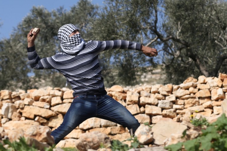 Palestinian protester hurls stones towards Israeli troops during clashes following a protest against the near-by Jewish settlement of Qadomem, in the West Bank village of Kofr Qadom near Nablus