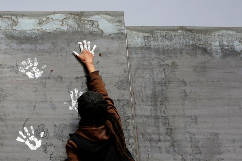 Activist paints the U.S.-Mexico border wall between Ciudad Juarez and New Mexico as a symbol of protest against US President Donald Trump''s new immigration reform in Ciudad Juarez, Mexico