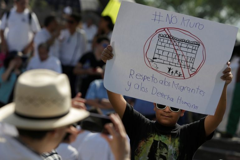 A demonstrator holds a placard during a protest against U.S. President Donald Trump''s proposed border wall and to call for unity, in Monterrey