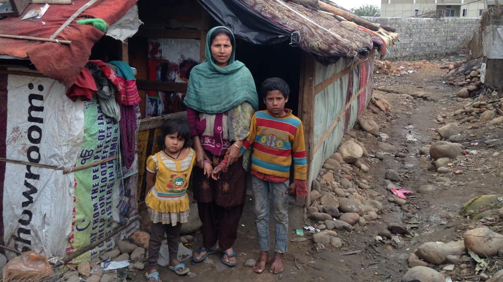 Noorjehan, who works at a pencil factory, with her children outside her hut in Jammu [Sunaina Kumar/Al Jazeera]