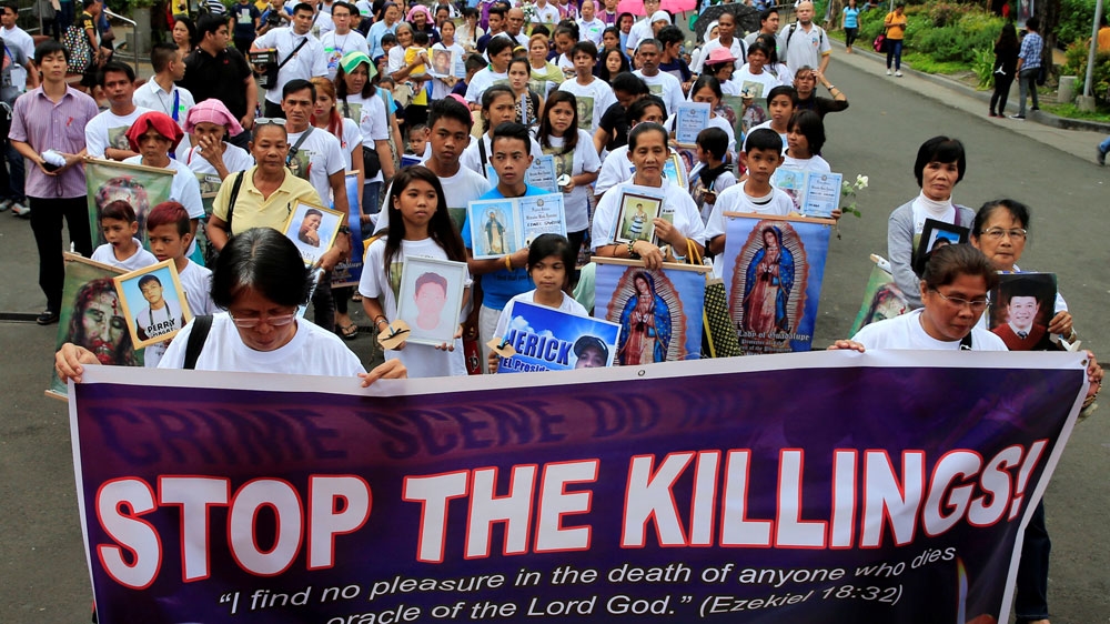 People hold photos of their family members, who they say were killed due to Duterte's anti-drug war in the Philippines [File: Reuters]