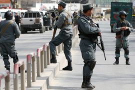 Afghan policemen keep watch at the site of a blast and gunfire at a military hospital in Kabul