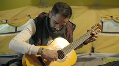 After organising the talent show, Mahmoud learned how to play the guitar [Screengrab/Al Jazeera]