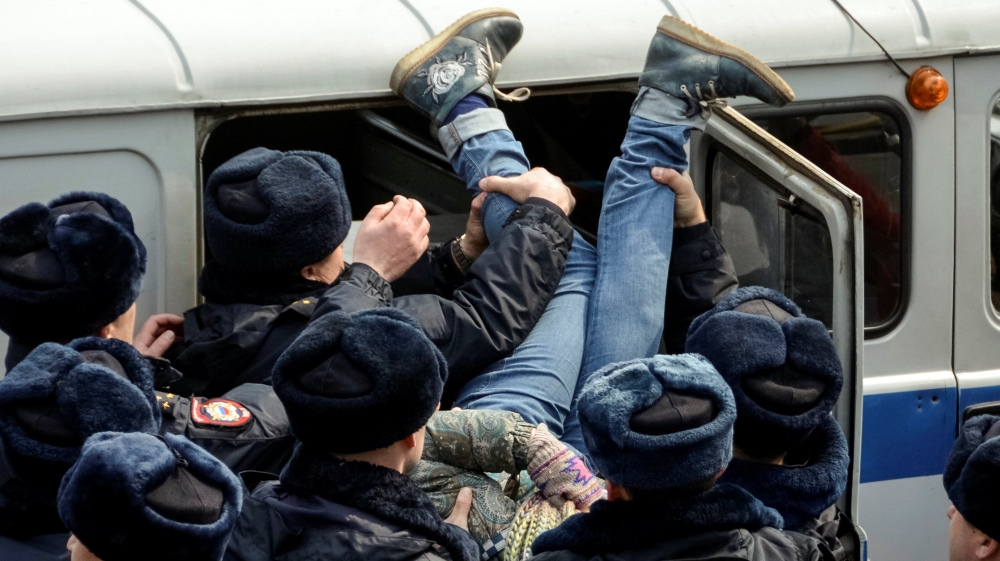 Police officers arrest an opposition supporter during a rally in the city of Vladivostok on Sunday [Reuters]