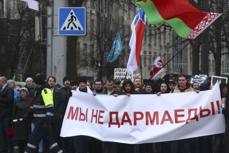 People hold banner at protest against increased tariffs for communal services and new taxes, including tax for those who are not in full-time employment, in Minsk