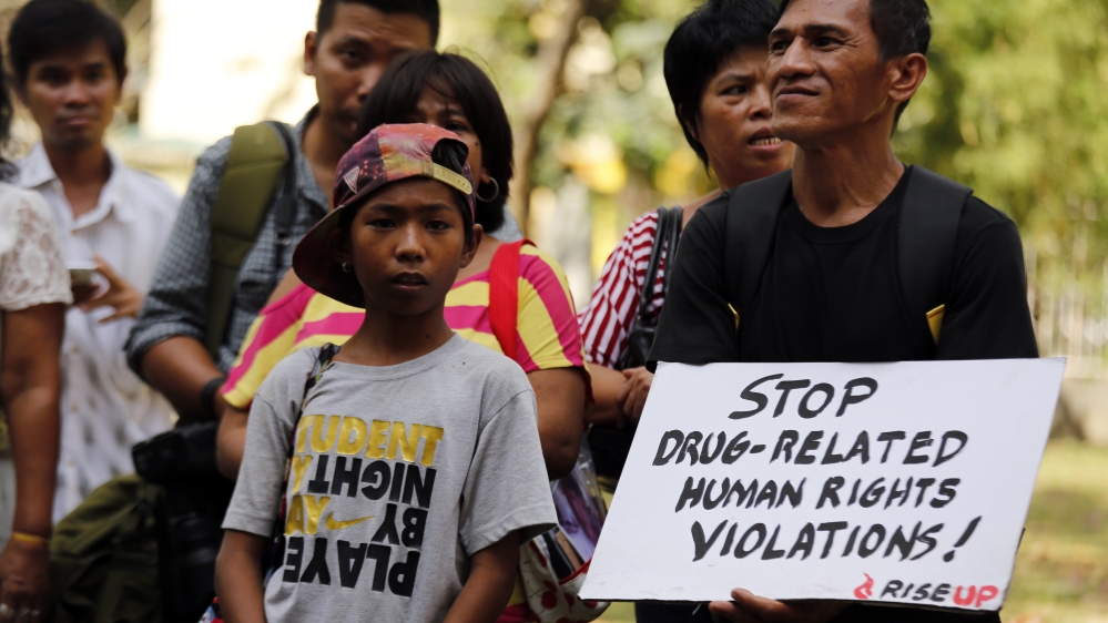 A Filipino holds a placard during a public forum dubbed 'Rise Up!' - a campaign to document cases of drug-related killings [EPA]