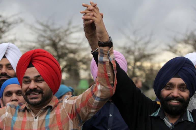 Sikh men hold hands during a vigil in honor of Srinivas Kuchibhotla, an immigrant from India who was recently shot and killed in Kansas, at Crossroads Park in Bellevue, Washington