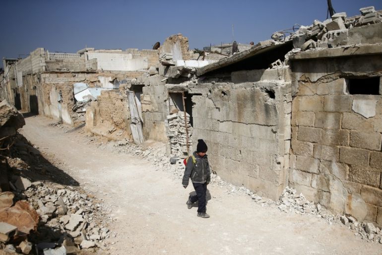 A boy walks along a street in the rebel held besieged Douma neighbourhood of Damascus