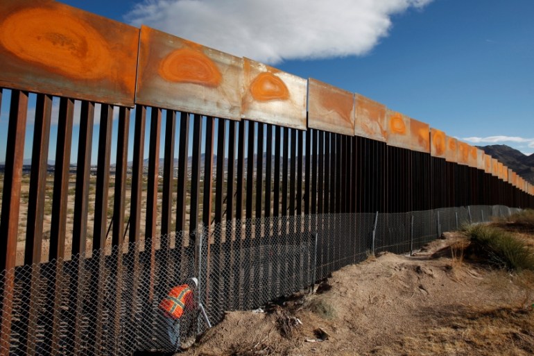FILE PHOTO: U.S. worker inspects a section of the U.S.-Mexico border wall at Sunland Park, U.S. opposite the Mexican border city of Ciudad Juarez