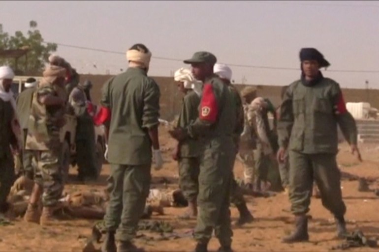 FILE PHOTO: Soldiers line up the bodies of the victims after a suicide car bomb attack on a military camp in Gao