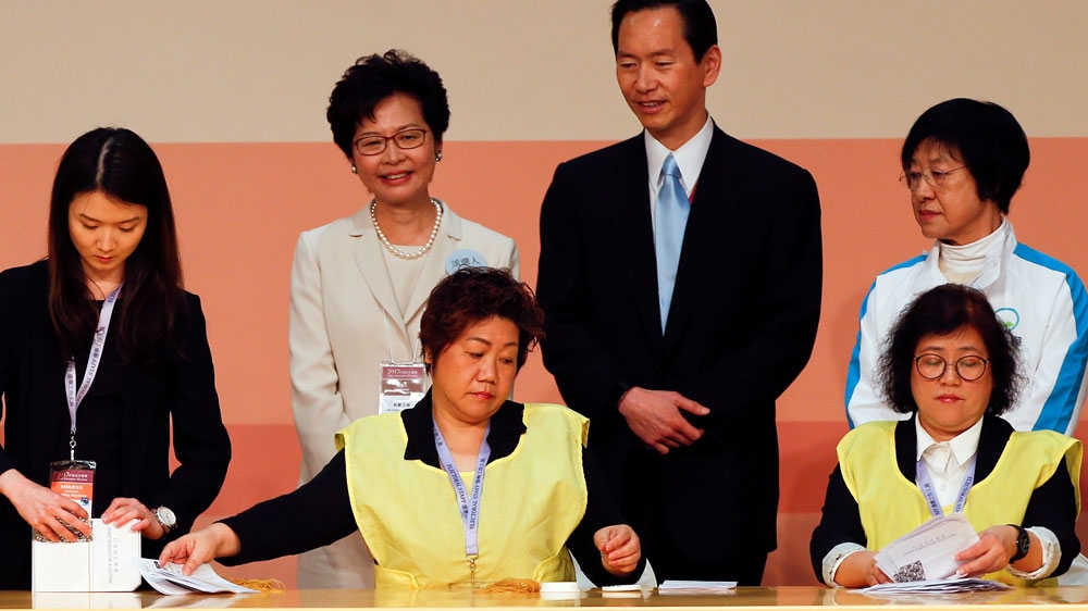  Carrie Lam, second left, smiles as officials counted votes during the election [Bobby Yip/Reuters] 