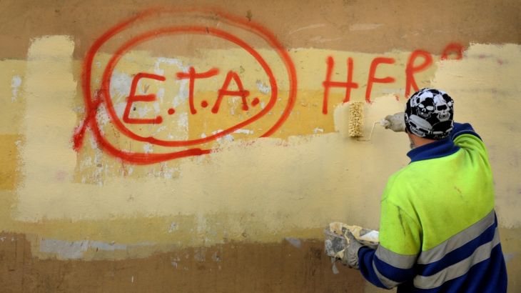 FILE PHOTO: A municipal worker paints over graffiti reading "ETA, The People Are With You" in the Basque town of Guernica